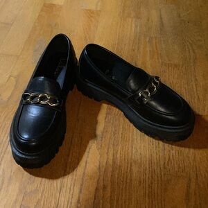 Black chunky platform loafers with gold chain detailing